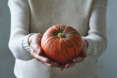 Close-up of hand holding pumpkin