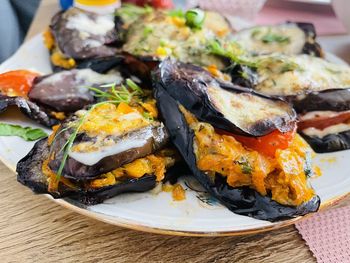 High angle view of baked eggplant with cheese in plate on table