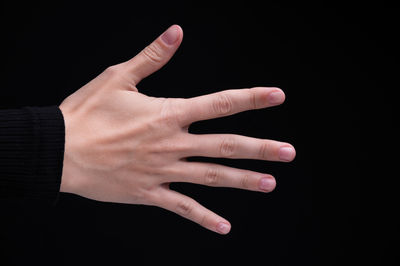 Close-up of hand against black background