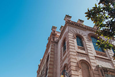 Low angle view of building against clear blue sky