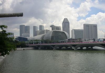 Bridge over river in city against sky