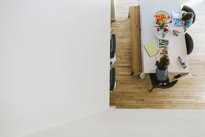 High angle view of brothers coloring on table at home