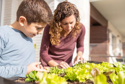 Mother and son working on a urban garden at home