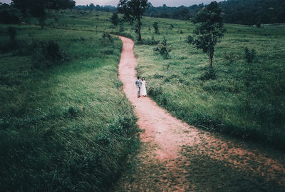 Rear view of person walking on footpath