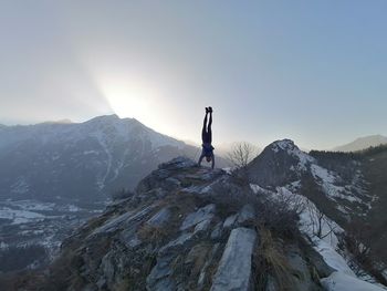 Man standing on snowcapped mountain against sky