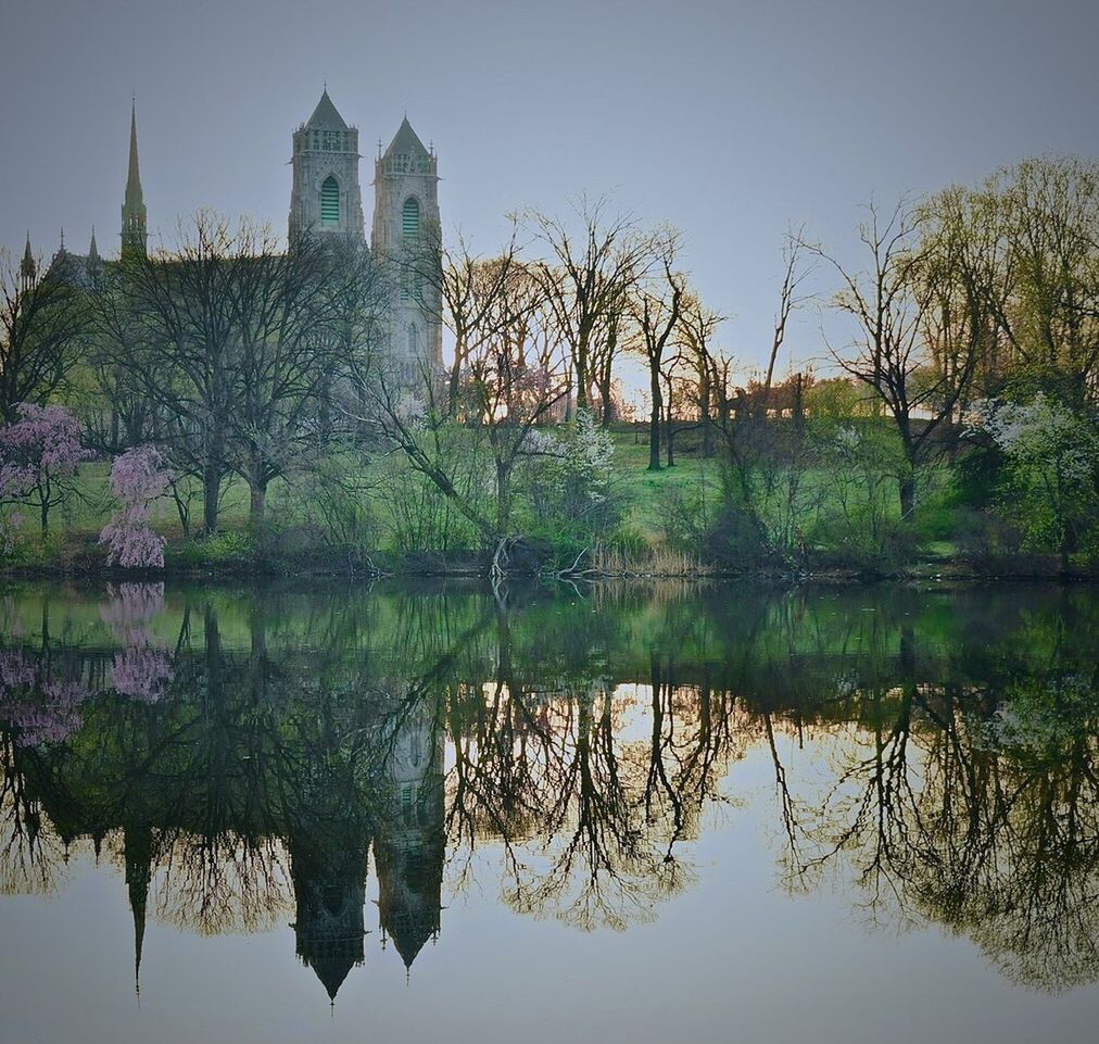 reflection, water, waterfront, tree, built structure, lake, sky, architecture, plant, nature, travel destinations, building exterior, no people, building, tranquility, travel, clear sky, tourism, day, outdoors, reflection lake