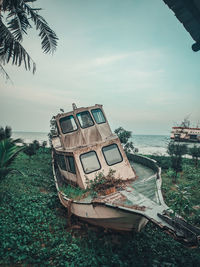 Abandoned boat on beach against sky
