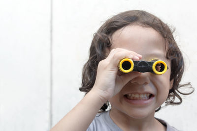 Close-up of cute boy looking through binoculars