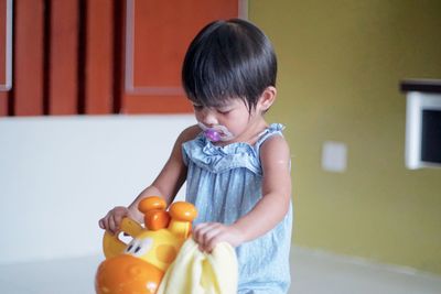 Cute girl playing with toy at home