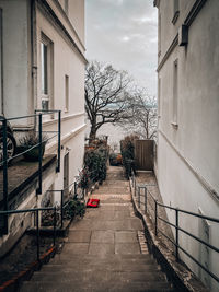 Footpath amidst buildings against sky