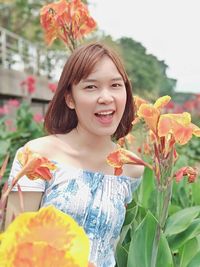 Portrait of smiling woman with red flower