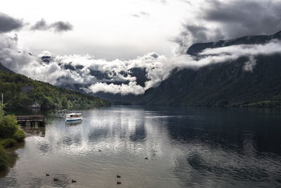 Scenic view of lake by mountains against sky