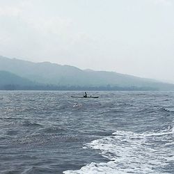 Calm sea with mountain range in background