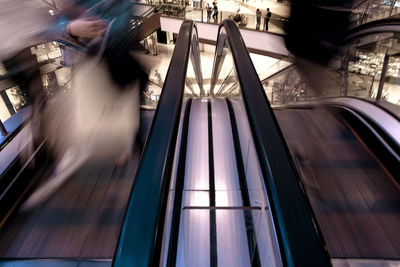 Blurred motion of people walking on escalator