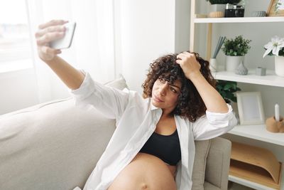 Side view of woman using mobile phone at home