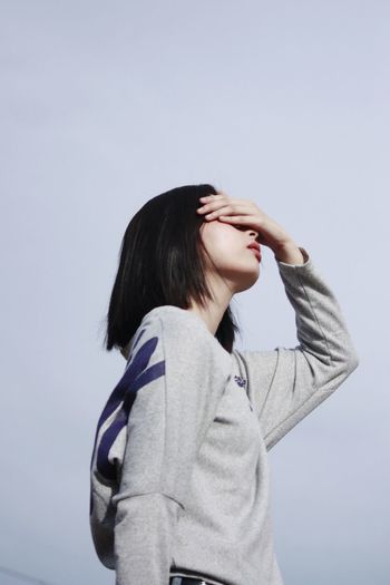 Young woman standing against clear sky