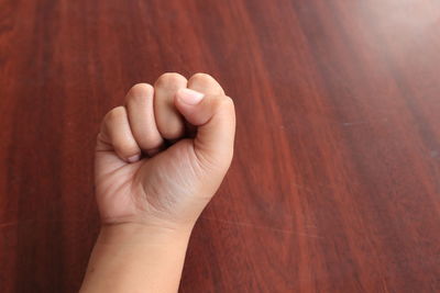 Close-up of person hand on wood