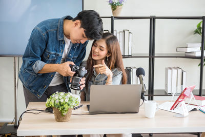 Portrait of young woman using laptop on table