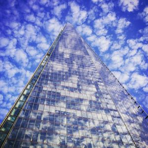 Low angle view of modern building against cloudy sky