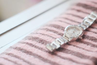 Close-up of wristwatch on bed at home