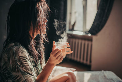 Midsection of woman drinking glass