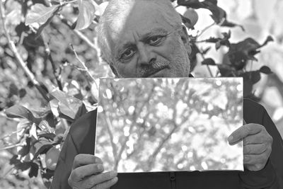 Portrait of man holding plant