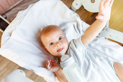 High angle view of cute baby boy sleeping on bed at home