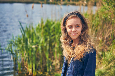 Portrait of smiling woman standing against plants