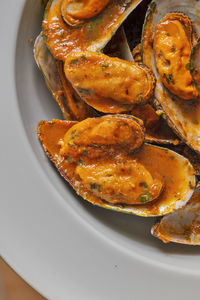 Close up of some mussels with tomato sauce.