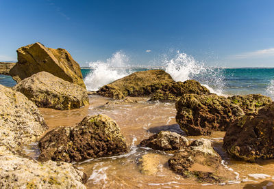 Rocks in sea against sky