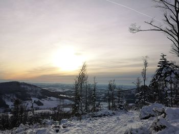 Scenic view of snow covered landscape against sky during sunset