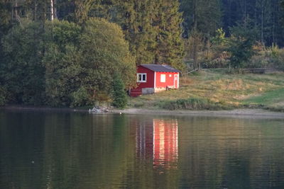 Scenic view of lake by house in forest