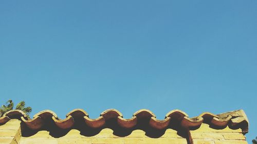 Low angle view of trees against clear blue sky