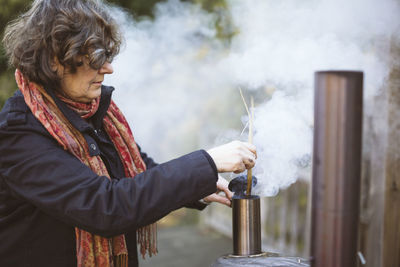 Woman starting fire in outdoor oven