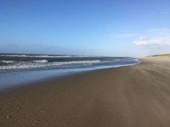 Scenic view of beach against blue sky