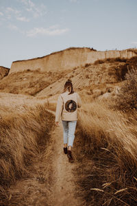 Woman standing on field against sky