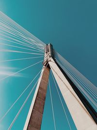 Low angle view of suspension bridge against clear blue sky