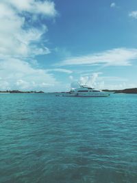 Boats in sea against cloudy sky