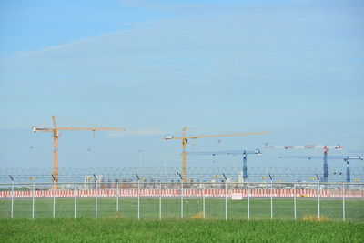 Wind turbines on field against sky