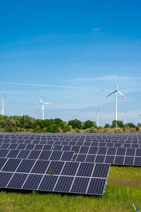 Solar power panels with wind turbines in the back seen in germany