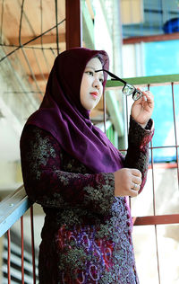 Portrait of young woman in hijab posing with glasses