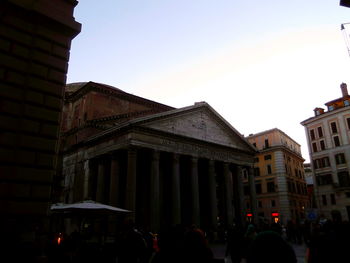 People in front of building against sky