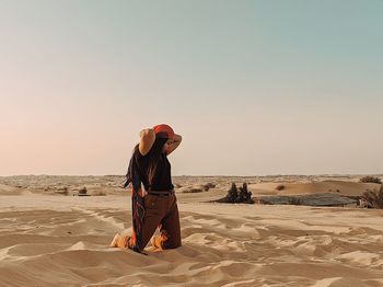 Man on beach against sky during sunset