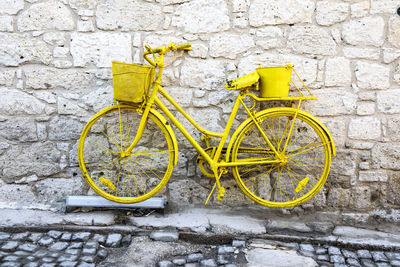 Yellow bicycle leaning on wall