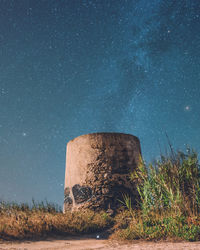 Old ruin on field against star field