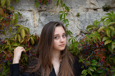 Portrait of young woman against plants