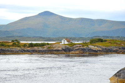 Scenic view of river by building against sky