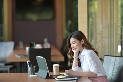 Woman sitting on table at restaurant