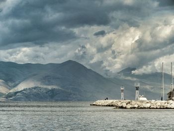 Lighthouse by sea against sky