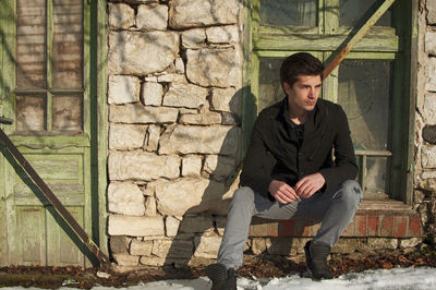 Thoughtful young man sitting by window